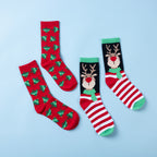 Two pairs of Christmas socks featuring red Christmas tree prints and a reindeer design with red and white stripes and green accents, displayed on a light blue background.