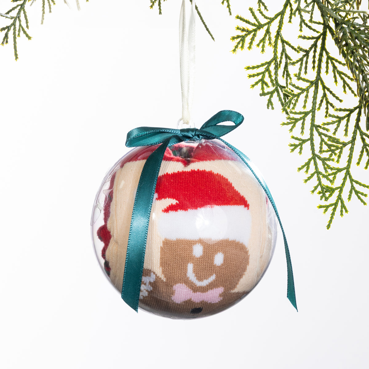 Christmas Wishes gingerbread sock bauble featuring festive socks rolled inside a clear ornament with a smiling gingerbread character wearing a Santa hat, finished with a teal ribbon bow.