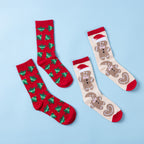 Two pairs of Christmas socks featuring red Christmas tree prints and a cream gingerbread design with Santa hats, hearts and red accents, displayed on a light blue background.