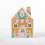 Gingerbread candy house cookie jar with a pink door, peppermint details, wreath and decorative white icing-style accents.