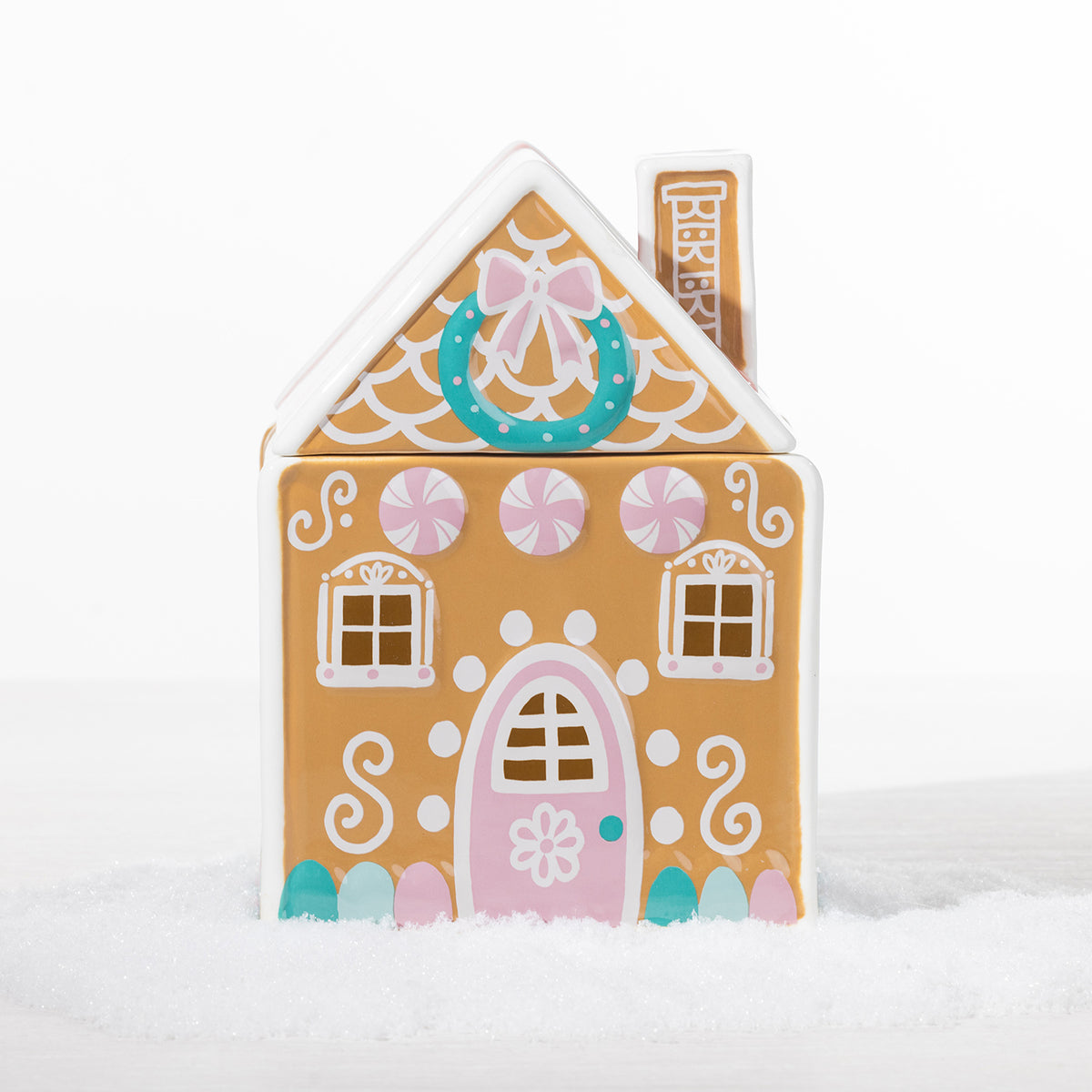 Gingerbread candy house cookie jar with a pink door, peppermint details, wreath and decorative white icing-style accents.