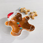 Gingerbread boy shaped plate featuring a Santa hat, colourful button details and white icing-style accents, displayed with gingerbread cookies.