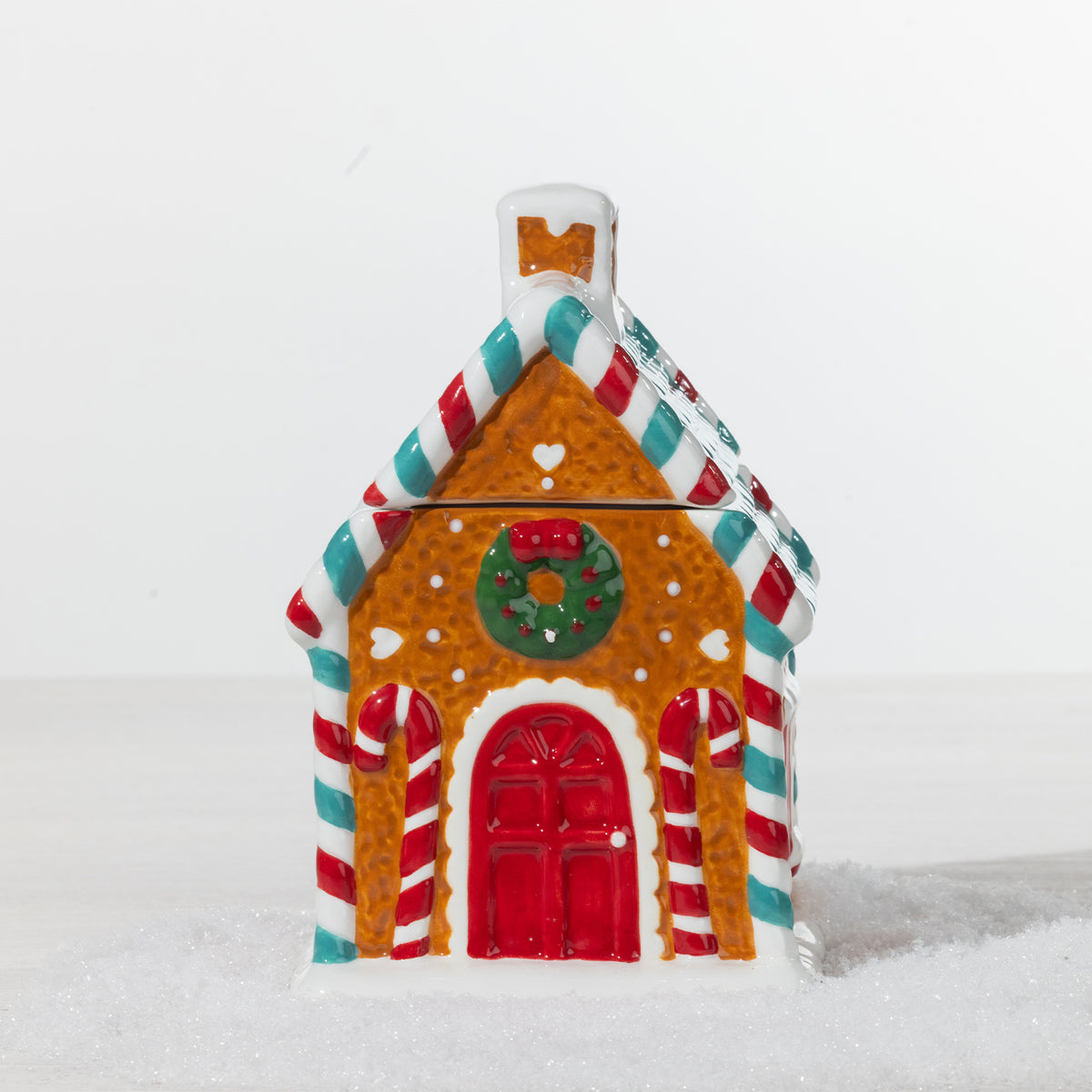 Gingerbread house cookie jar featuring a festive gingerbread design with candy cane details, red door, Christmas wreath and teal roof.