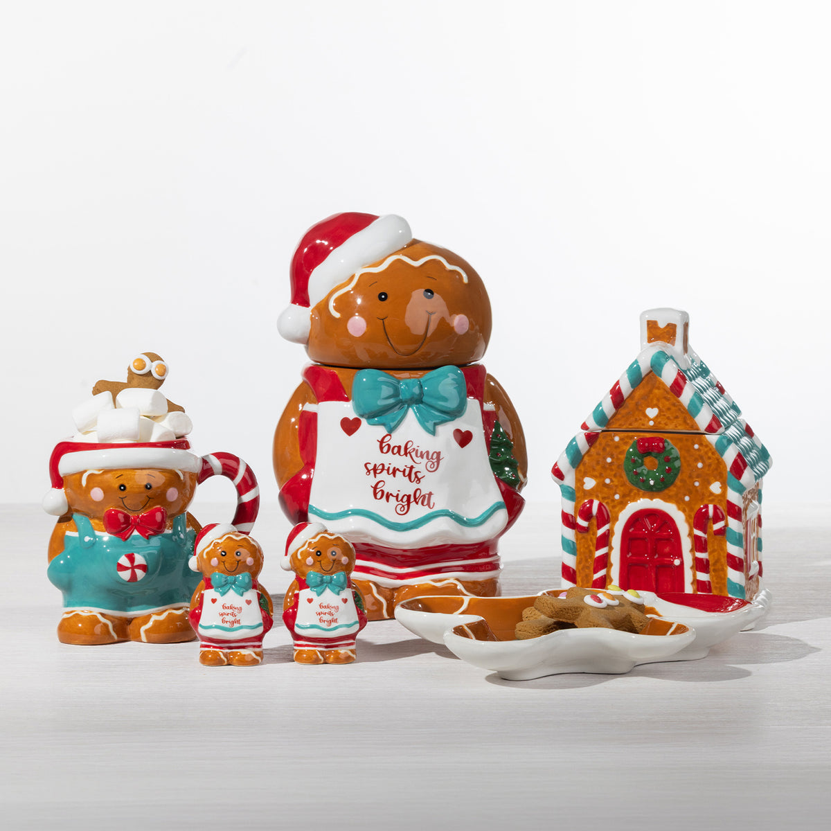 Christmas Wishes gingerbread collection featuring a gingerbread house cookie jar, gingerbread boy cookie jar, serving plate and matching festive pieces.