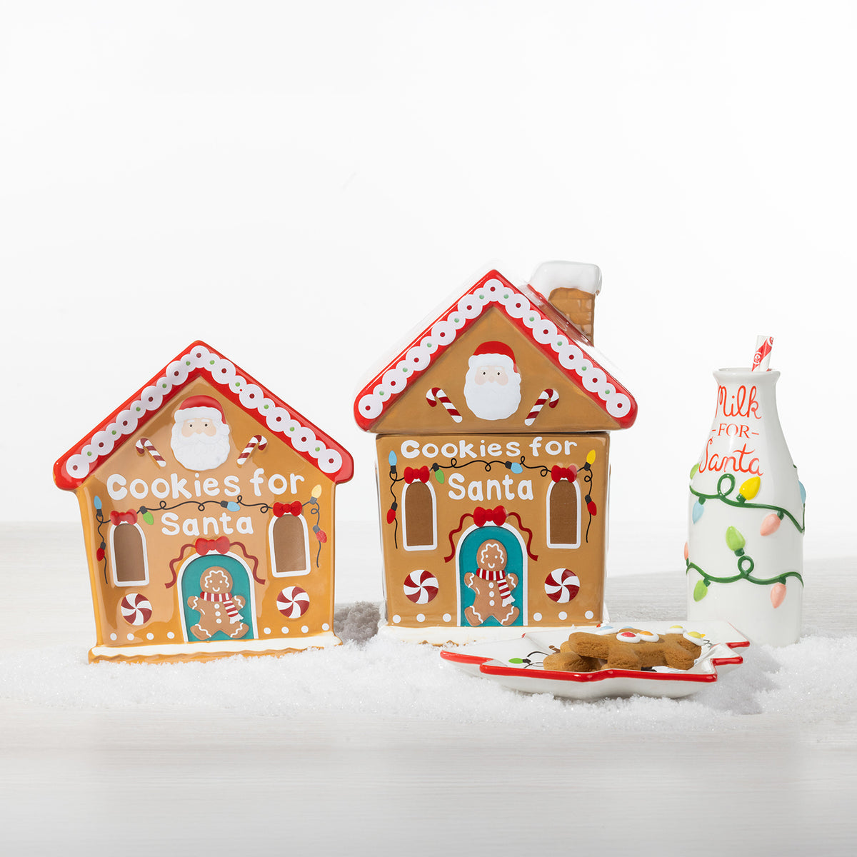 Christmas Wishes collection featuring two gingerbread house cookie jars, a Milk for Santa bottle and Christmas tree shaped cookie plate.