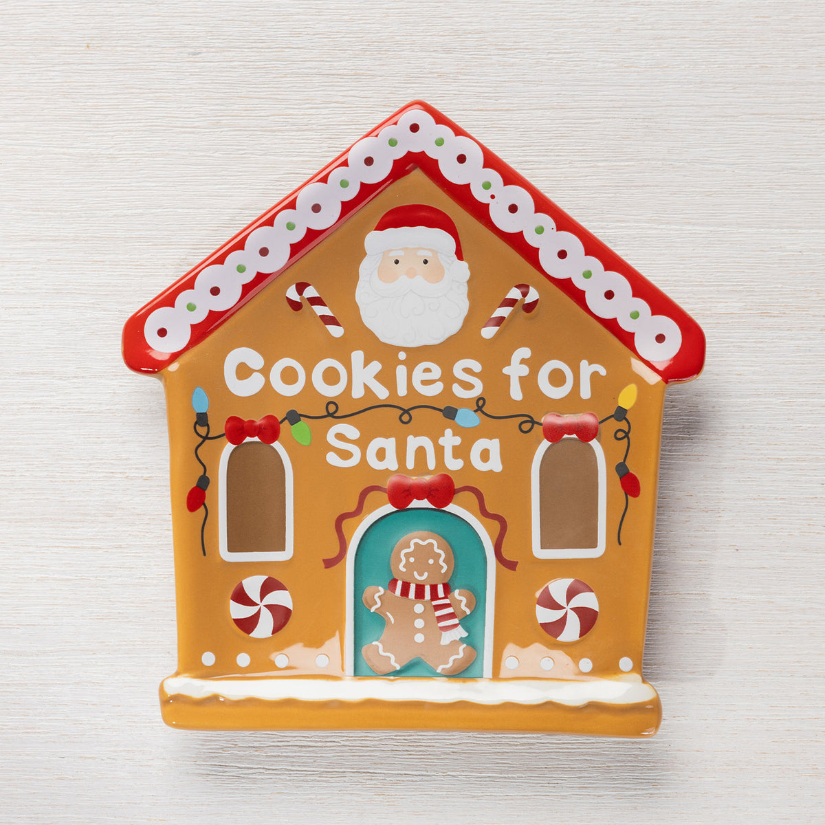 Gingerbread house shaped Christmas plate featuring Santa, candy canes, colourful lights, peppermint details and “Cookies for Santa” lettering.
