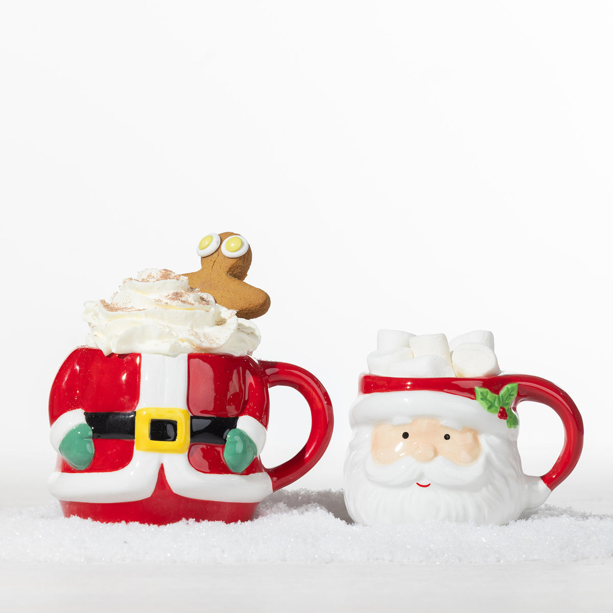 Santa Claus mug set displayed separately, with the body mug topped with whipped cream and a gingerbread man and the Santa face mug filled with marshmallows.