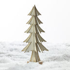 A small decorative wooden Christmas tree stand made of layered light wood, standing upright in white faux snow against a bright white background.