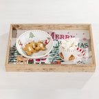 A rectangular wooden serving tray with a clear glass top, styled with a white ceramic bowl of gingerbread cookies and a white mug filled with marshmallows, set against a festive Christmas print insert.