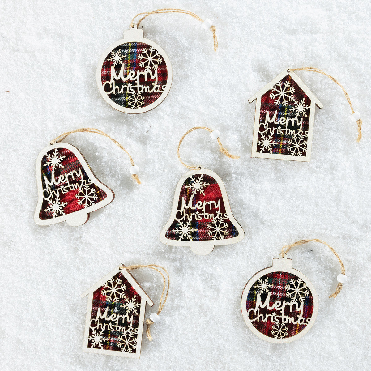 Six Christmas ornaments shaped like bells, houses, and round baubles, each with a red and black plaid pattern, white snowflakes, and 'Merry Christmas' text, displayed on a white textured background.
