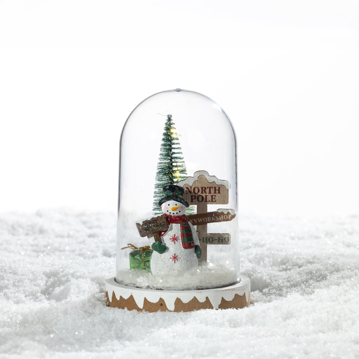 Christmas Wishes North Pole Snow Globe LED Décor – Festive North Pole snow globe-style LED decoration featuring a snowman, Christmas tree, wrapped present and directional sign beneath a clear dome.