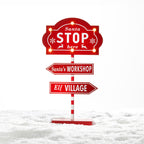 Christmas Wishes Santa Stop Here LED Sign – Freestanding red and white Christmas sign featuring glowing LED lights, “Santa Stop Here”, Santa’s Workshop and Elf Village directional signs.