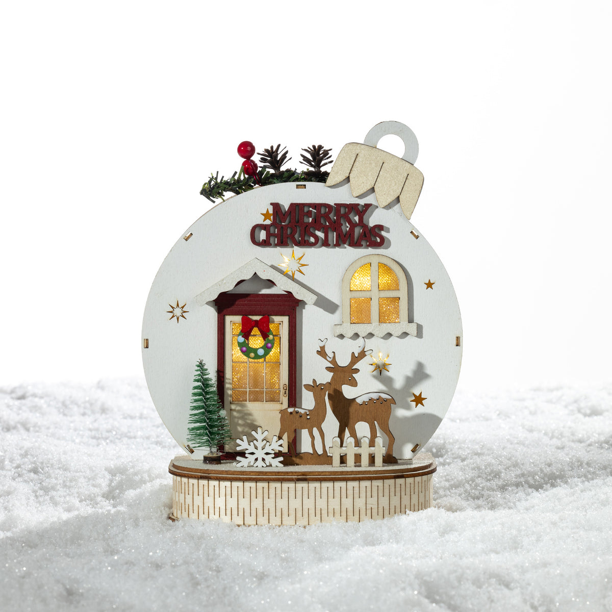 Christmas Wishes Wooden Merry Christmas Bauble LED Décor – Wooden bauble-shaped Christmas decoration featuring a festive front door scene with reindeer, miniature trees, “Merry Christmas” lettering and warm LED lighting.
