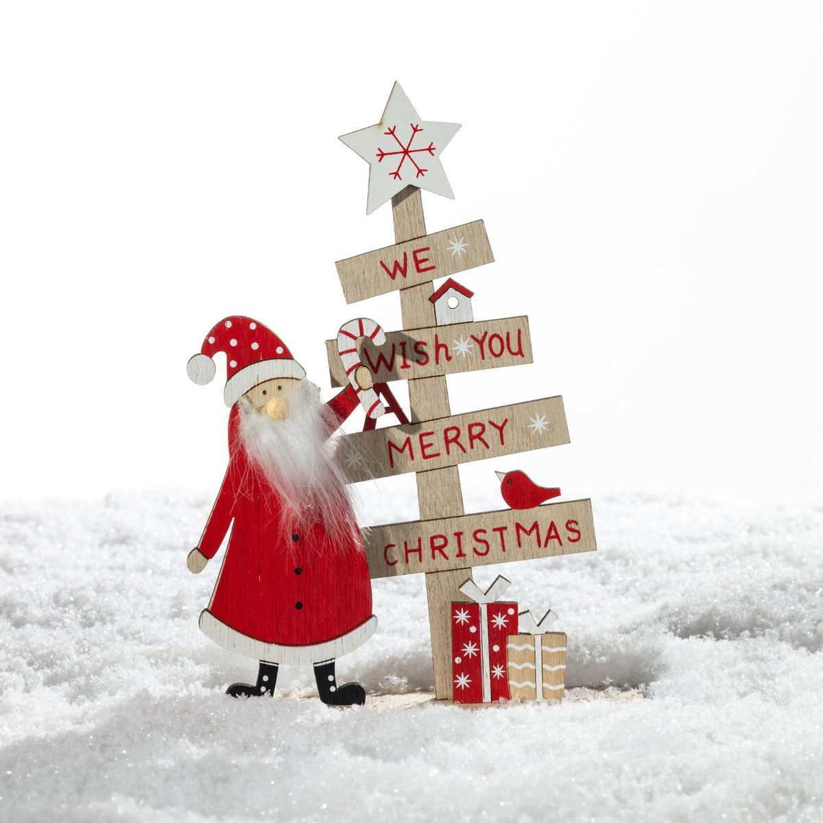 Christmas Wishes Wooden Wish You A Merry Christmas Décor – Wooden Christmas decoration featuring Santa beside a tree-shaped sign reading “We Wish You A Merry Christmas”, finished with a star, bird and wrapped presents.