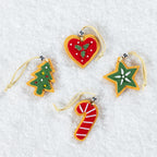 Four Christmas tree-shaped ornaments in different designs, including a red heart with green holly, a green Christmas tree with ornaments, a green star with a white flower, and a red and white striped candy cane, all with gold hanging loops, displayed on a white textured background.