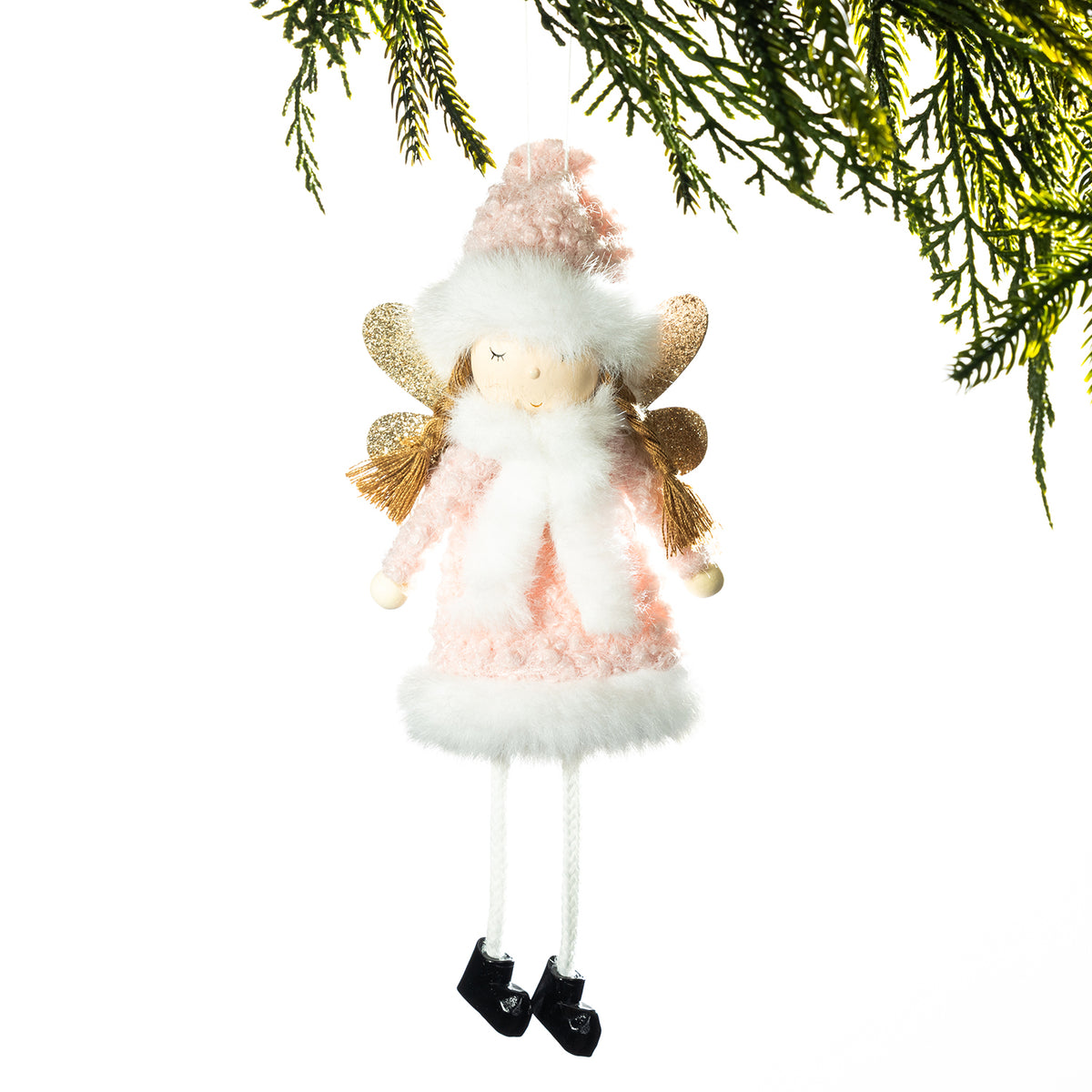 A hanging Christmas angel ornament with a pink and white fluffy dress, gold wings, and black shoes, shown against a white background with pine branches at the top.