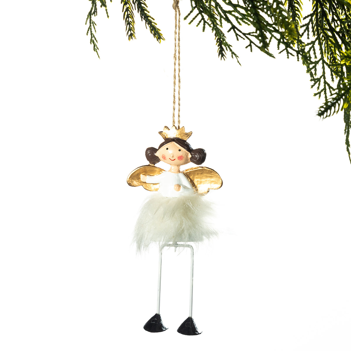 A hanging fairy Christmas ornament with a white fluffy dress, gold wings, a small gold crown, and long thin legs, suspended against a white background with pine branches at the top.