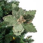 A green artificial poinsettia-style Christmas tree ornament with textured leaves and glittery gold berry accents, shown attached to a green artificial Christmas tree branch against a white background.