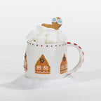 A festive gingerbread house mug filled with marshmallows and topped with a playful gingerbread character, styled against a snowy white backdrop.