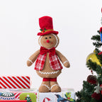 A gingerbread figurine standing on Christmas presents and next to a Christmas Tree.