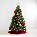 Christmas Wishes Channel Velvet Tree Skirt in rich red, featuring a channelled velvet design, displayed beneath a decorated Christmas tree.