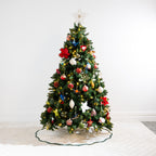 Christmas Wishes Scallop Linen Look Tree Skirt in Natural with dark green scalloped edging, displayed beneath a decorated Christmas tree.