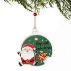 A Christmas advent-style ornament shaped like a football, hanging from a red string under pine branches. The ornament is dark green with a cartoon Santa Claus figure, white stars, the phrase 'Days until Santa Arrives,' and a small gift box graphic.