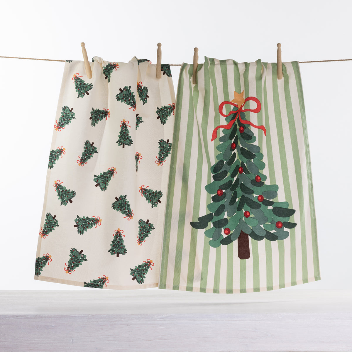 Christmas Wishes Christmas Tree tea towel 2 pack with cream mini Christmas tree print and green striped towel featuring a large decorated Christmas tree.