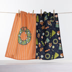 Christmas Wishes Festive Icons tea towel 2 pack with orange wreath design and navy Christmas icon print hanging on a line.