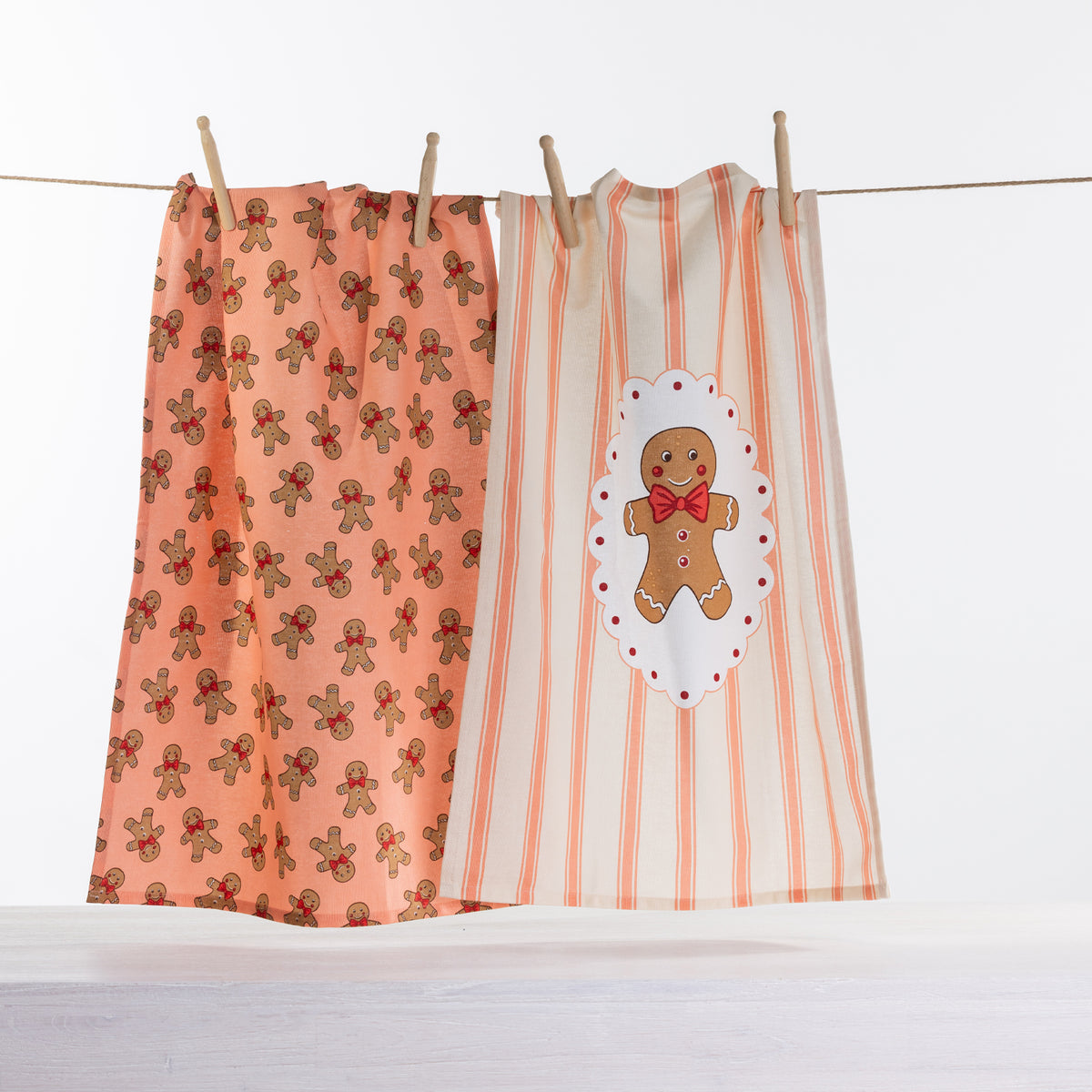 Christmas Wishes Ginger Cookie tea towel 2 pack with peach gingerbread man print and cream striped towel featuring a large gingerbread character.