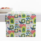 Christmas Wishes Kiwi Christmas table runner styled across a white table, featuring Christmas trees, native birds, wreaths, ornaments and gifts.