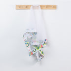 Christmas Wishes Kiwi Christmas Food Cover hanging from a wooden hook, featuring white mesh with colourful festive Kiwi Christmas print trim.