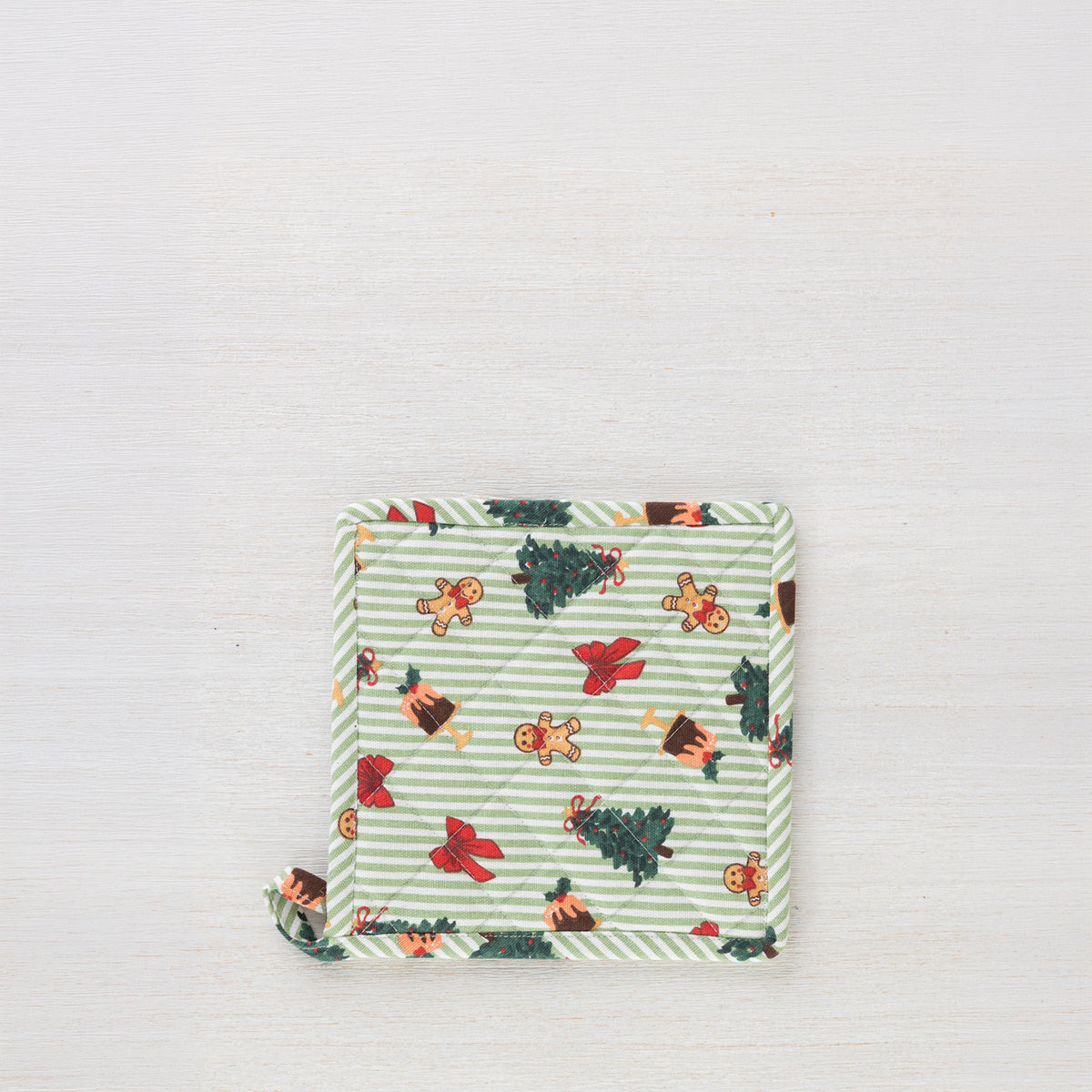 Christmas Wishes Classic Christmas pot holder shown individually, featuring quilted green striped fabric with Christmas trees, gingerbread people, red bows and puddings.