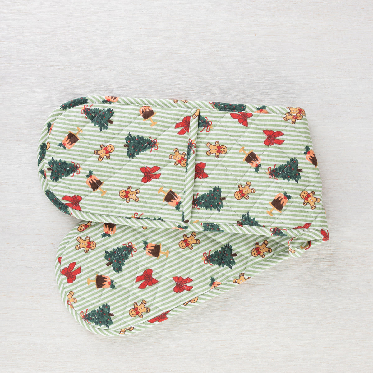 Christmas Wishes Classic Christmas Double Oven Glove laid flat, featuring green and white stripes with Christmas trees, gingerbread people, bows and Christmas puddings.