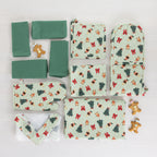 Christmas Wishes Classic Christmas kitchen collection arranged flat, featuring green napkins and coordinating festive kitchen textiles in the Classic Christmas print.