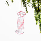 Clear glass Christmas lollie hanging decoration featuring soft pink spiral stripes and pink edging, hanging from festive greenery against a white background.