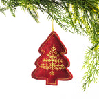 A red embroidered Christmas tree hanging decoration featuring an intricate gold snowflake design and gold stitching around the edges, suspended from festive greenery against a white background.