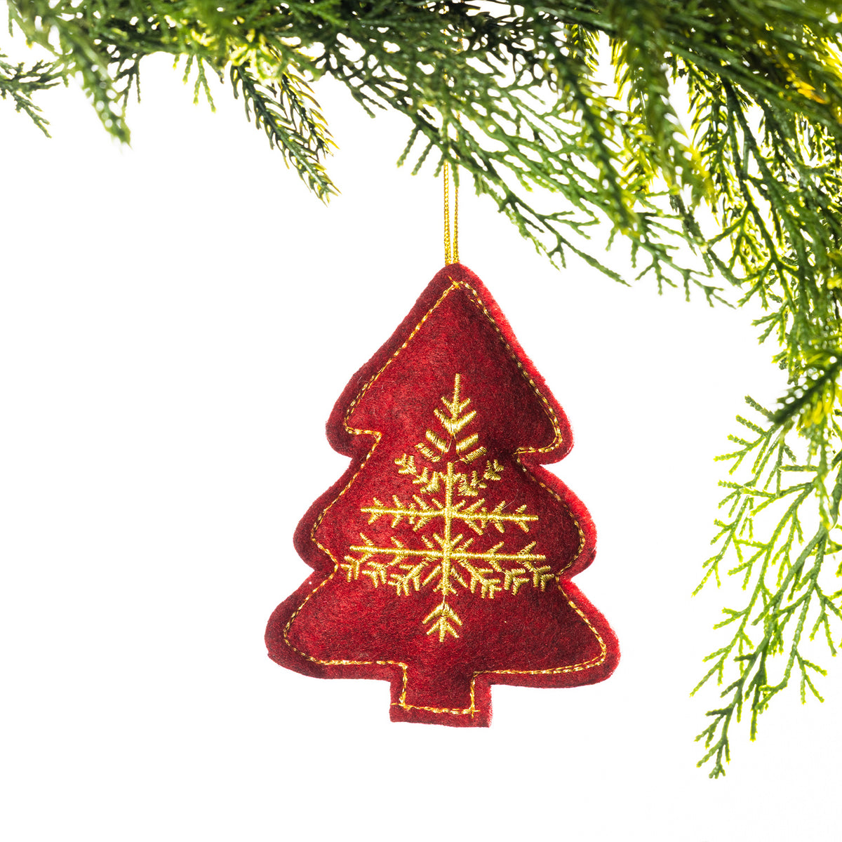 A red embroidered Christmas tree hanging decoration featuring an intricate gold snowflake design and gold stitching around the edges, suspended from festive greenery against a white background.