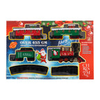 Christmas-themed train set in its retail packaging, featuring a red and green Santa-themed locomotive and holiday passenger cars on black tracks, with festive red and blue box design.