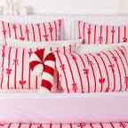 Christmas Wishes Bows Duvet Cover Set in Pink and Red, styled with matching pillowcases, white textured cushions and a red and white candy cane cushion.