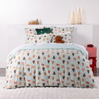 Christmas Wishes Sugar Spruce Duvet Cover Set featuring festive gingerbread men, Christmas trees and gingerbread houses on a pale mint background, styled on a bed with Christmas decorations.