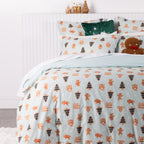 Side view of the Christmas Wishes Sugar Spruce Duvet Cover Set styled with matching pillowcases, festive cushions and gingerbread decorations.