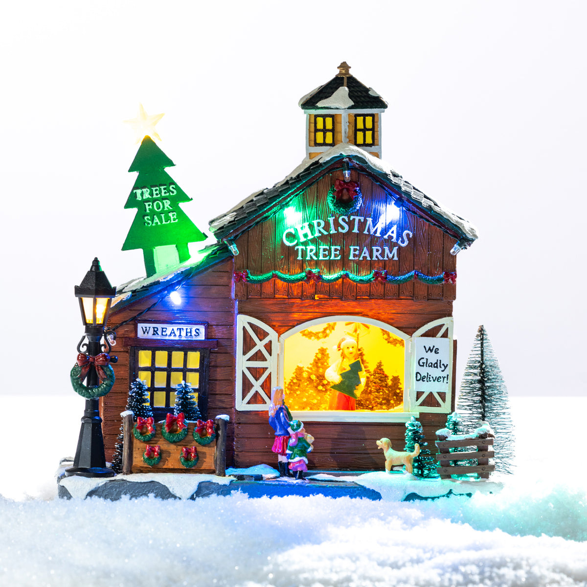 A whimsical illuminated Christmas tree farm featuring a snowy barn, colourful lights, festive wreaths and tiny shoppers choosing their perfect tree.