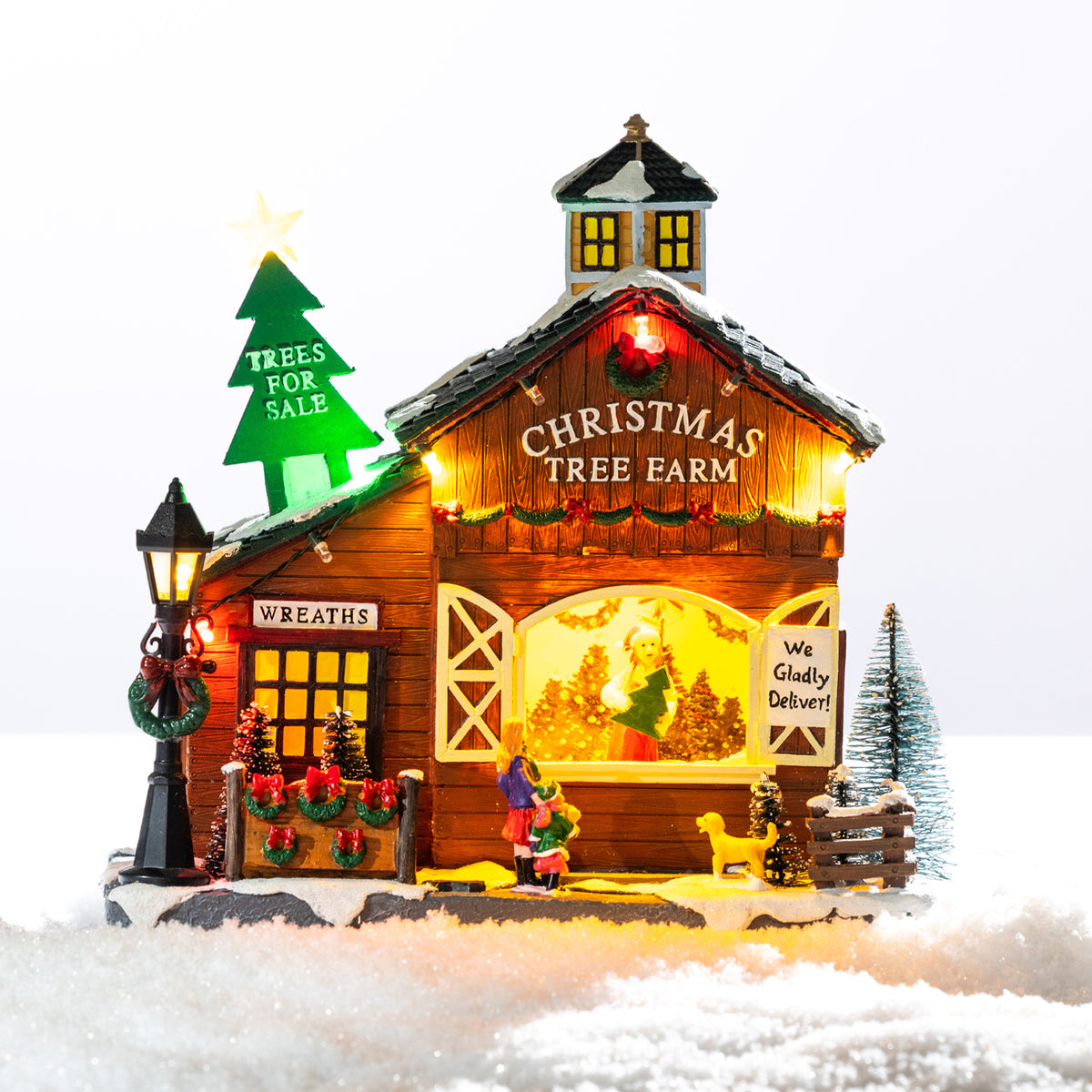 A whimsical illuminated Christmas tree farm featuring a snowy barn, colourful lights, festive wreaths and tiny shoppers choosing their perfect tree.