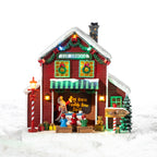 A whimsical illuminated Elf School featuring colourful Christmas lights, tiny elves, festive gifts and playful North Pole details in a snowy setting.