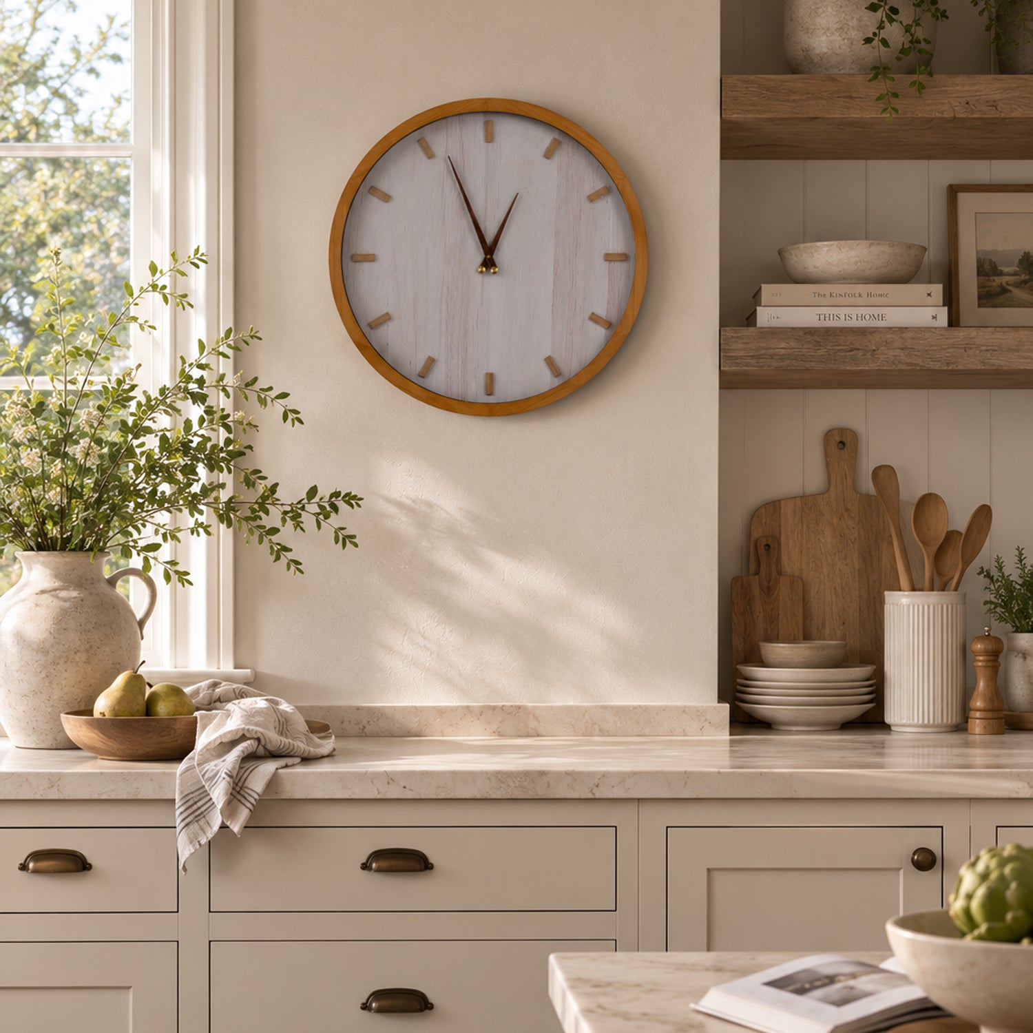 A natural timber-framed wall clock with a softly whitewashed face adds warm, modern farmhouse style to a bright, thoughtfully styled kitchen.