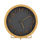 A round tabletop clock with a tan frame and stand, a dark charcoal gray face, and matching tan numerals and hands, shown on a plain white background.