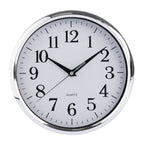 A round wall clock with a polished silver metal frame and a white face, featuring black Arabic numerals and black hands, with the word 'QUARTZ' printed below the 12.
