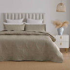 Mushroom colour quilted coverlet set styled on a bed in a neutral bedroom.