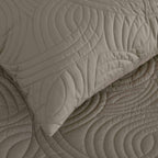 Mushroom colour quilted coverlet close-up showing textured stitched pattern and matching pillowcase.